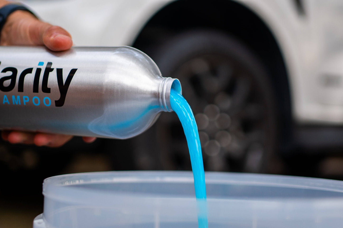 Clarity Car Wash Shampoo being poured into a bucket, preparing for a wash. Showing off it’s fluorescent blue colour.