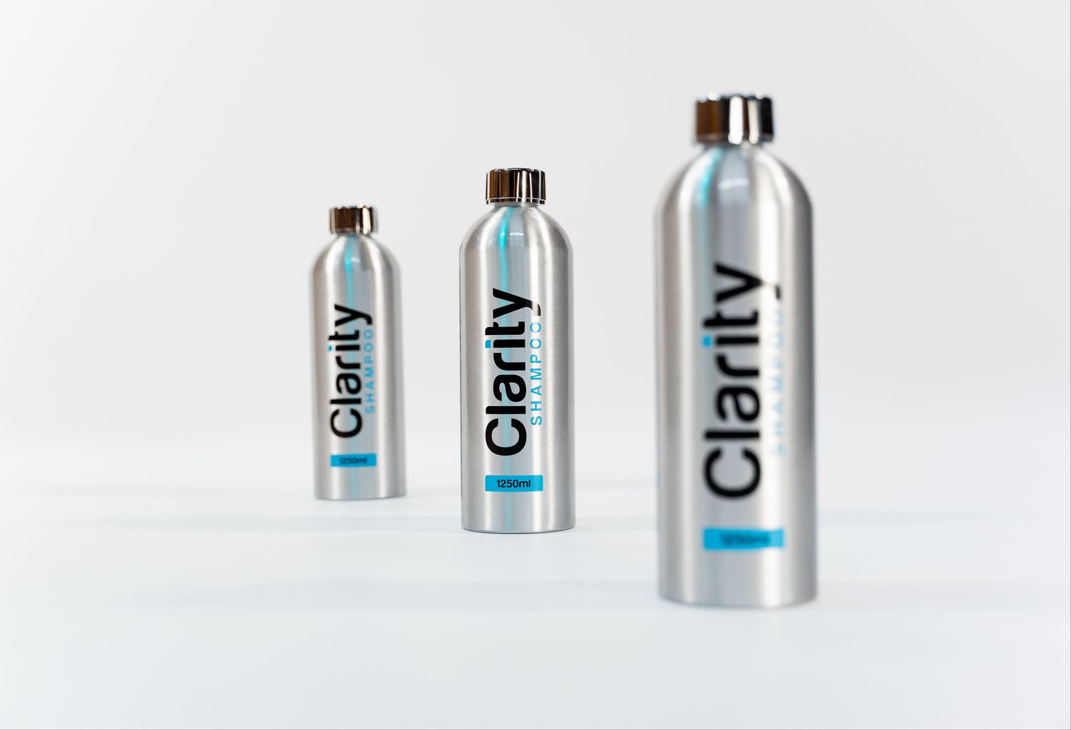 Three silver bottles labeled 'Clarity' on a light gray background